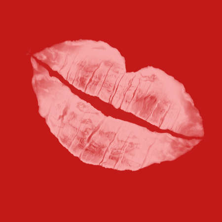 pink lip imprint against red backgroundの写真素材