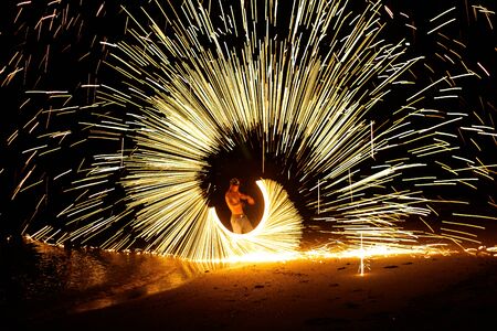 Man playing fire batonの写真素材