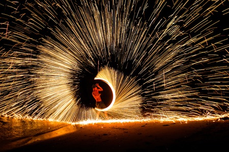 Man playing fire batonの写真素材