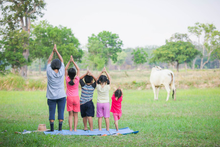 Grandmothers and children play yoga outdoors.の写真素材