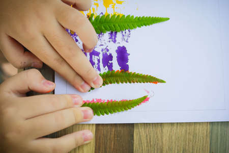 Asian cute girl doing leaf art , 
A cute Asian girl makes a leaf stamping art , 
Color stamping with...
