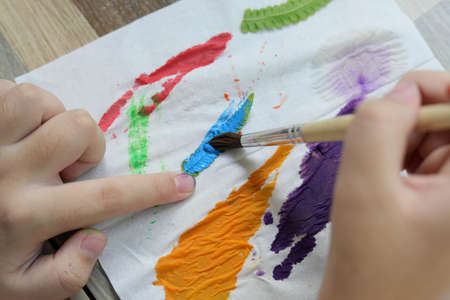 Asian cute girl doing leaf art , 
A cute Asian girl makes a leaf stamping art , 
Color stamping with leaves , art from natural materials
 , selective focus ,beautiful sea with us, Thailand.の写真素材