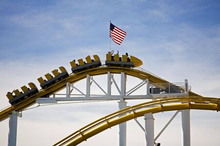 Roller Coaster peaking on track with flag on topの写真素材