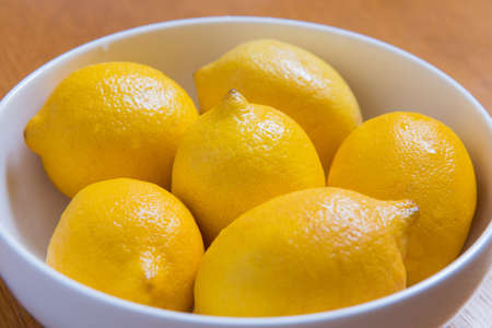 Fresh yellow lemons on a wooden background. sweet lime, vitamin c.の写真素材