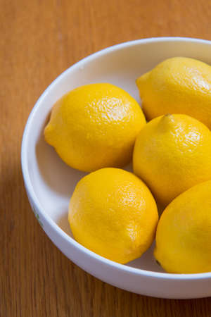 Fresh yellow lemons on a wooden background, sweet lime, vitamin c.の写真素材