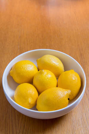 Fresh yellow lemons on a wooden backgroundの写真素材