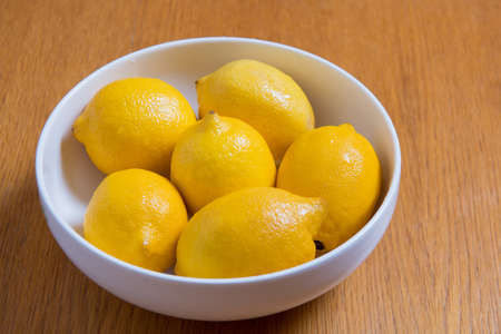 Fresh yellow lemons on a wooden backgroundの写真素材