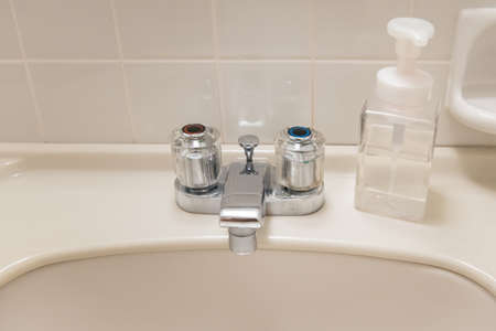 Washbasin and hand soap in the white bathroom of the hotel