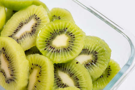 Many kiwi slices are placed in a glass crisper.の写真素材