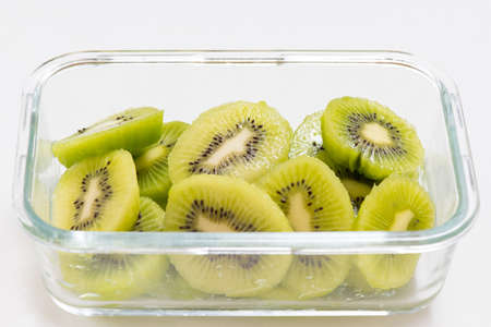 Many kiwi slices are placed in a glass crisper.の写真素材