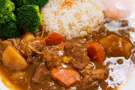 Pork Curry Rice on wooden background ( Onsen tamago, Potato, enoki mushroom, onion, broccoli, Japanese style,)の写真素材