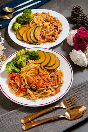 Delicious tomato spaghetti on the table (Served with cauliflower, pumpkin, shiitake mushrooms)の写真素材