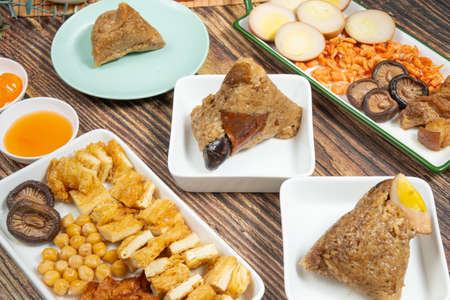 rice dumpling is a traditional Chinese rice dish made of glutinous rice and wrapped in bamboo leaves, Dragon Boat Festival is making and eating zongziの写真素材