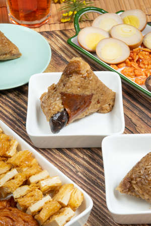 rice dumpling is a traditional Chinese rice dish made of glutinous rice and wrapped in bamboo leaves, Dragon Boat Festival is making and eating zongziの写真素材