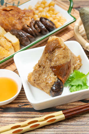rice dumpling is a traditional Chinese rice dish made of glutinous rice and wrapped in bamboo leaves, Dragon Boat Festival is making and eating zongziの写真素材