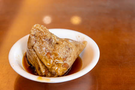 rice dumpling is a traditional Chinese rice dish made of glutinous rice and wrapped in bamboo leaves, Dragon Boat Festival is making and eating zongzi with familyの写真素材