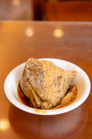 rice dumpling is a traditional Chinese rice dish made of glutinous rice and wrapped in bamboo leaves, Dragon Boat Festival is making and eating zongzi with familyの写真素材