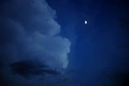 half moon glows on the face of the cloudの写真素材