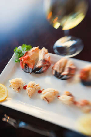 appetizer of local rock crab claws and a glass of chardonnay wineの写真素材