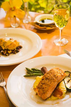 honey glazed and pecan crusted salmon, shrimp cakes and a glass of chardonnay wineの写真素材