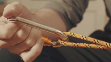 Mans hands tying a mountaineering knot on a rope