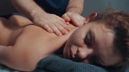 Mans hands massaging womans backの写真素材