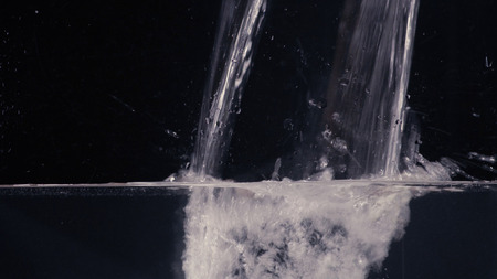 Flowing water on black background close upの写真素材