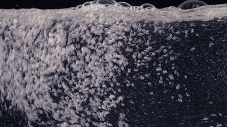Bubbles under water on black background close up