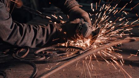 Close up of man's hands smoothing metal grateの写真素材