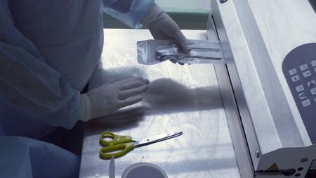 The surgical assistant packaging the instrument for laparoscopic operation in plastic bagsの写真素材