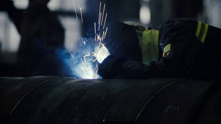 Close up of welder at work in metal industry. Manufacture of trucks.の写真素材