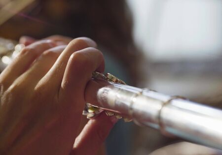 Extreme close up of young woman playing a fluteの写真素材