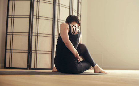 A young woman performing yoga-asanas in the hallの写真素材