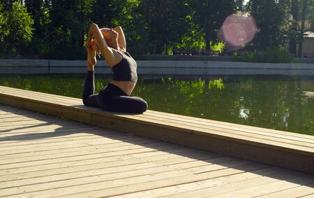 Young woman doing yoga exercises in the park