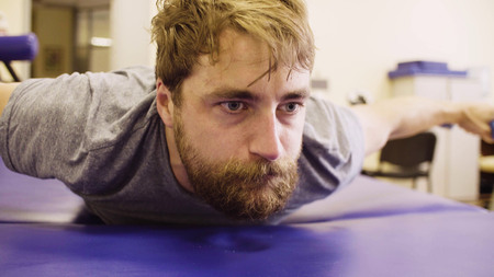 Face of a disable man during exercises at the rehabilitation clinicの写真素材