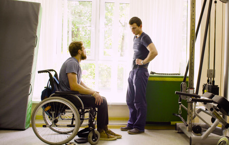 Disabled man in wheelchair talking with a doctor