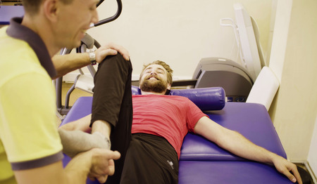 Doctor helping disabled man at the rehabilitation center