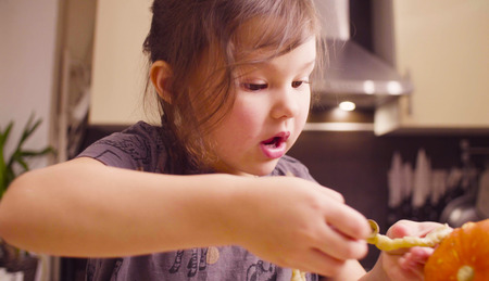 Little girl sitting at the desk sculpts something from waxの写真素材