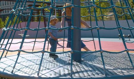 Mom turns the baby on the carousel. Slow motionの写真素材