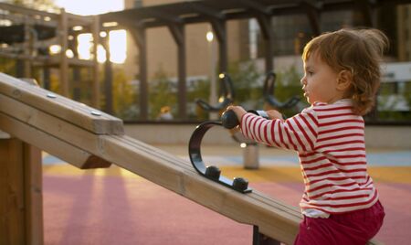 Little girl on the playground in the park. Good sunny dayの写真素材
