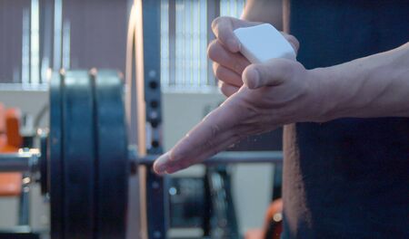 Close up bodybuilder chalking the hands. Beginning of workoutの写真素材