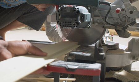 Close up carpenter cutting a plank with circular saw. Builder and woodworkingの写真素材