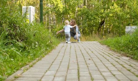 Unhappy kid goes to his mom. Smiling mother is hugging him. Family, Mother's Day