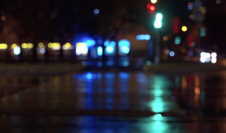 Blurred night city traffic lights. Rainy. Reflection of the colorful lights on the wet asphalt. City backgroundの写真素材