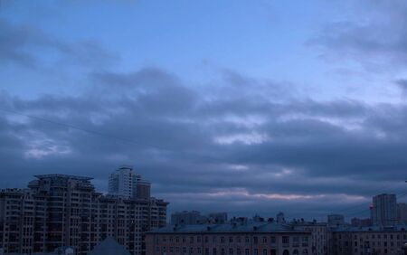 Dark cloudy sky over city buildings. Evening time, autumn. Sky backgroundの写真素材
