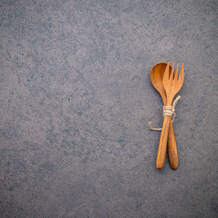 Wooden spoon and fork set up on dark stone background.の写真素材