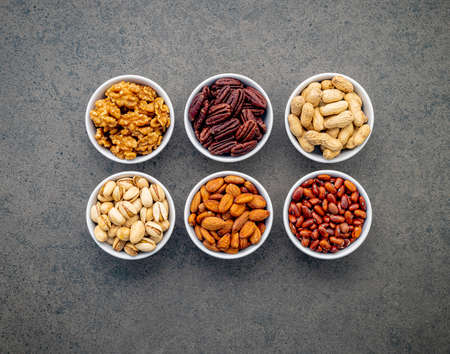 Mixed beans and nuts in the white bowl on brown dark stone background.の写真素材