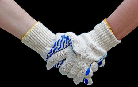 Labor handshake with safety gloves isolated on blackの写真素材