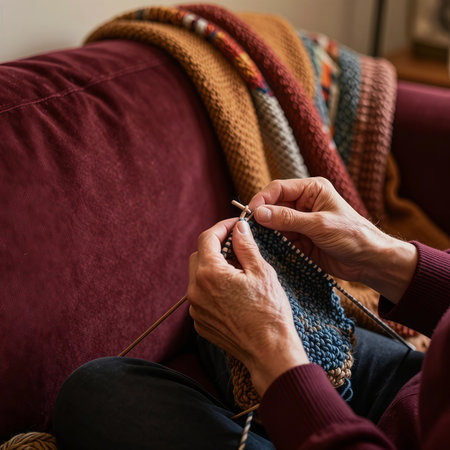 Close up of a woman's hands knitting on a sofa at homeの素材