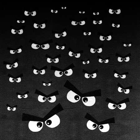 Crowd of angry eyes on dark gray background. Pattern of many human cute eyes are visible in the dark...